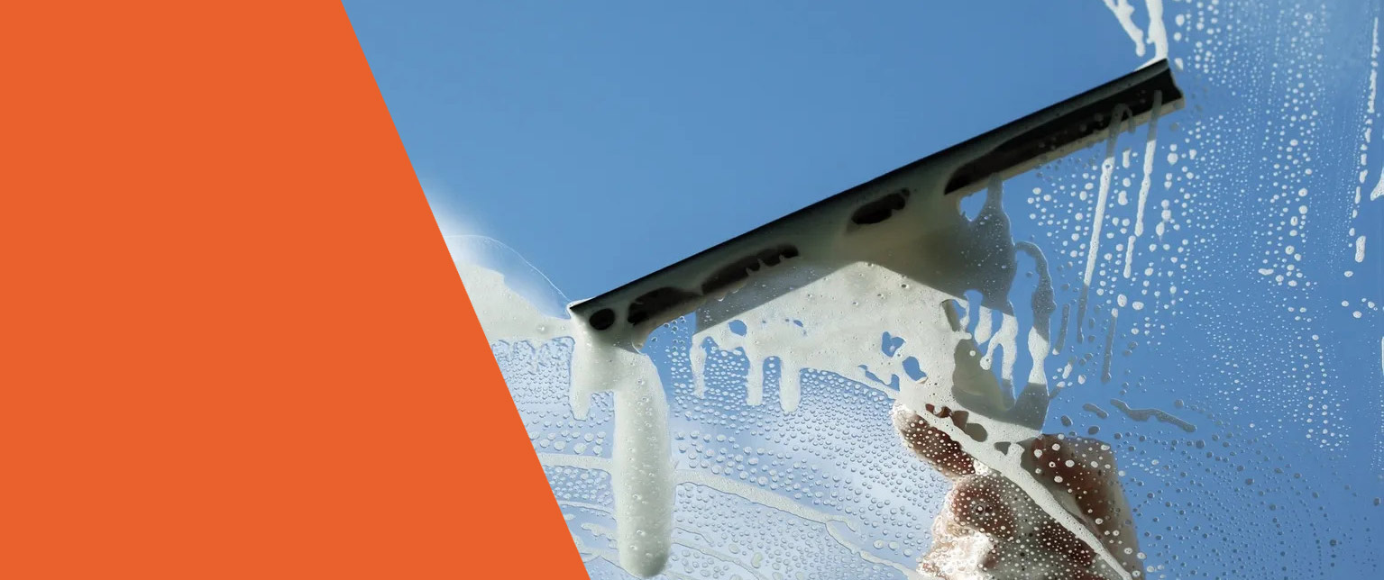 Squeegee pulling foam across a window